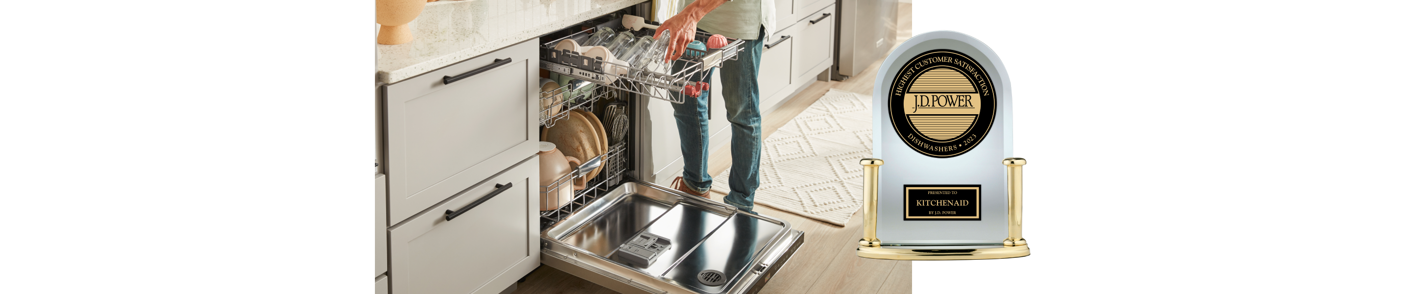 A person loading items in the third rack of a dishwasher and the J.D. Power award trophy.