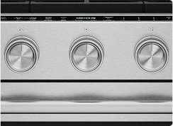 A close up on the knobs of a stainless steel oven.
