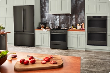 A suite of Black Ore appliances in a white kitchen.