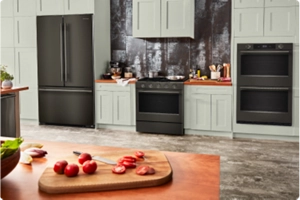 A suite of Black Ore appliances in a white kitchen.