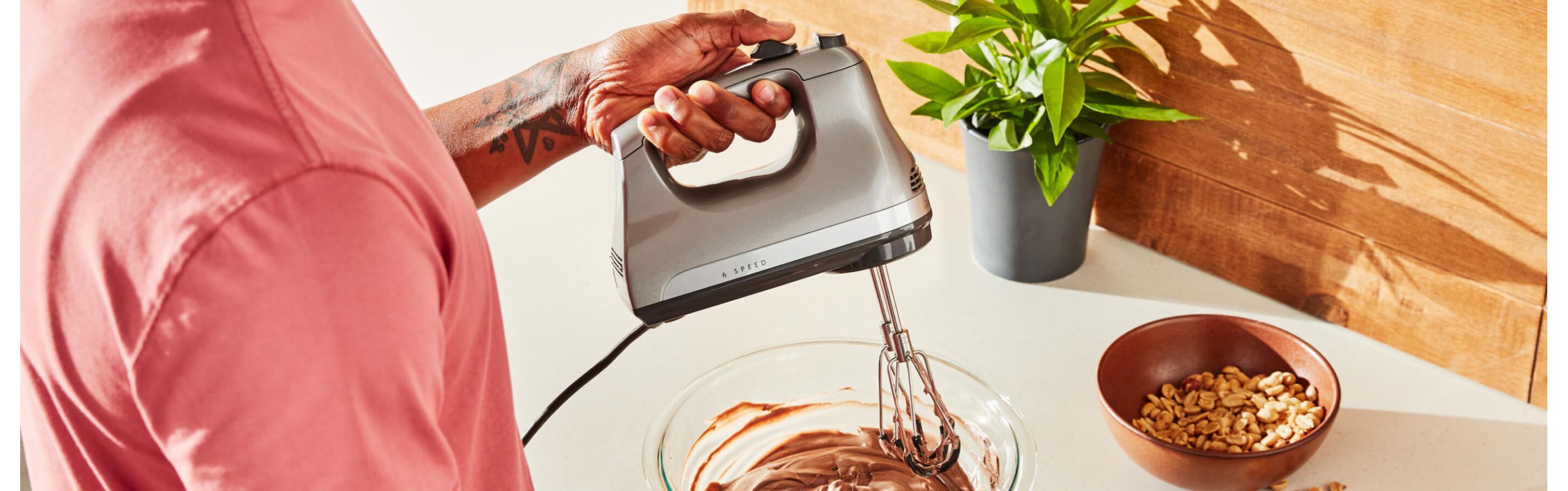 A person using a 6-Speed Hand Mixer.
