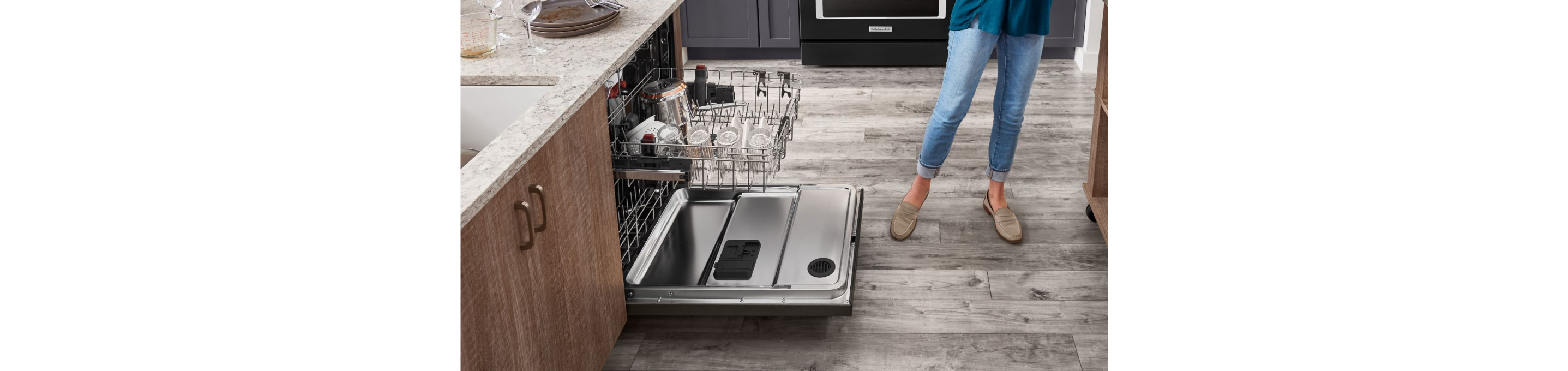 An open dishwasher in a bright, clean kitchen.