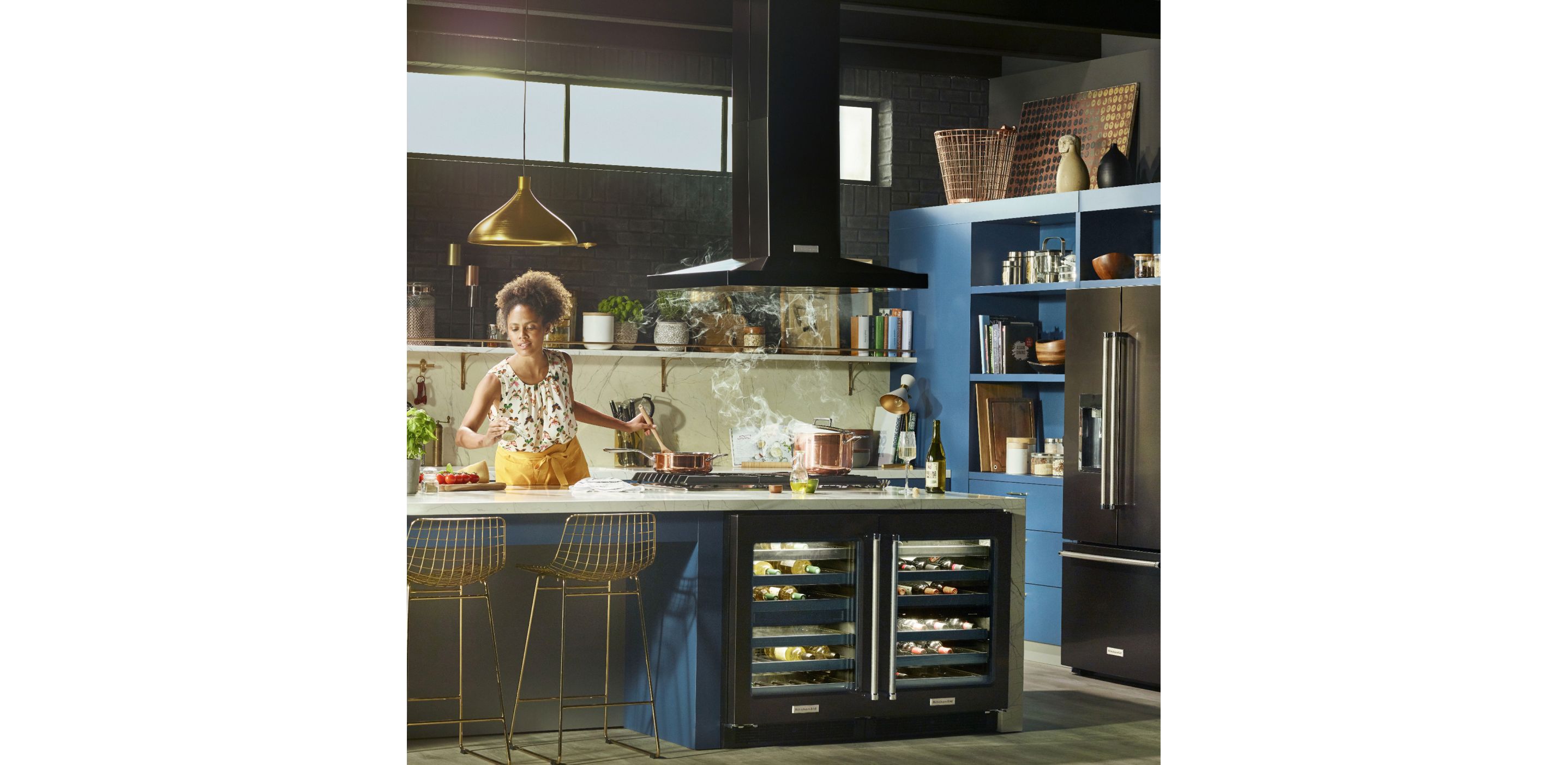 Young female Maker in a stylish, updated kitchen cooking over a pot of steaming liquid.