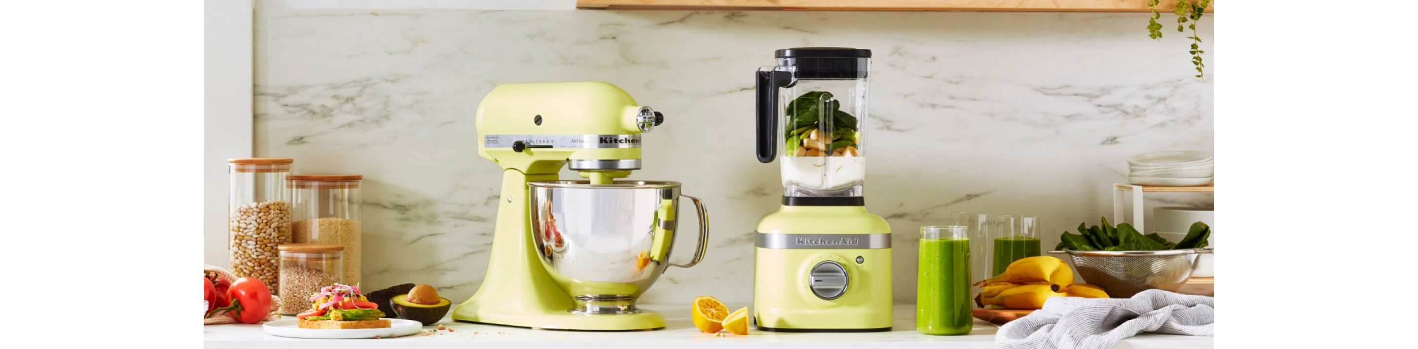 The Kyoto Glow stand mixer and blender on a white countertop surrounded by ingredients and prepared recipes.