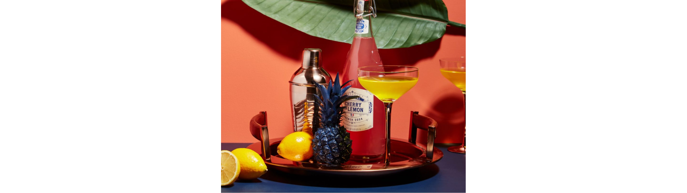 A cocktail tray with bold yellow, blue and pink ingredients.