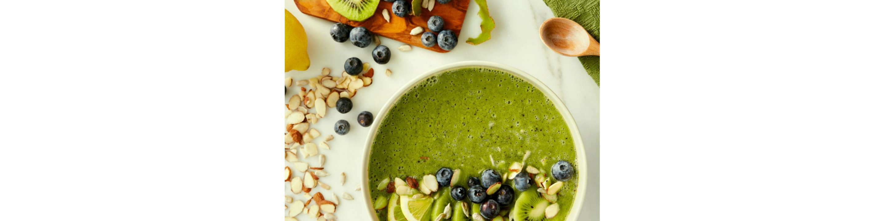 A bright green smoothie bowl with various ingredients.