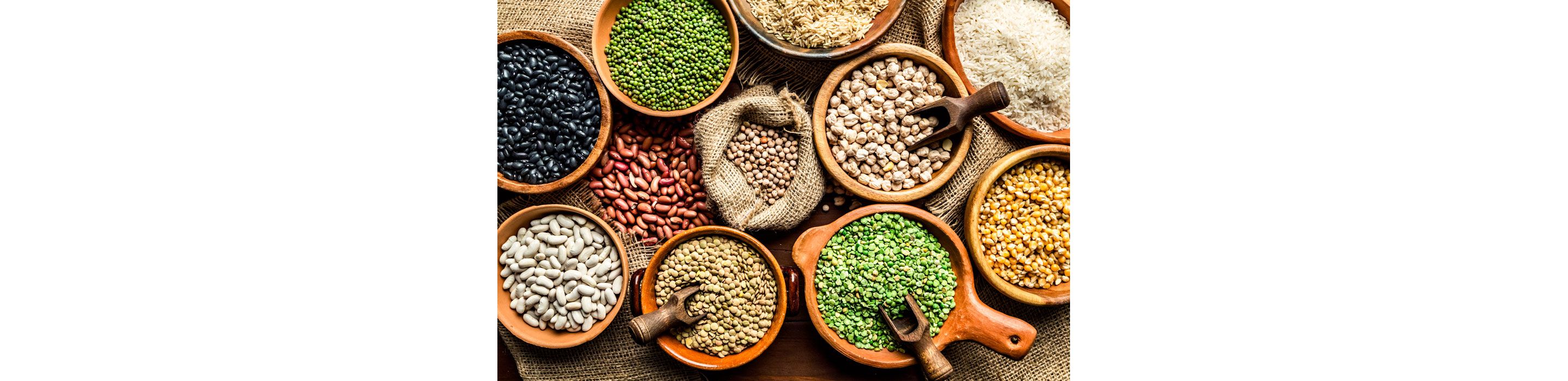 Assorted bags and bowls filled with a variety of beans.