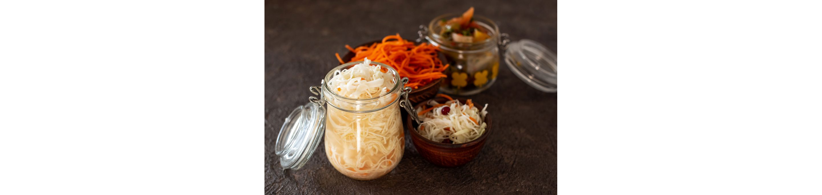 A large, open glass jar filled to the rim with sauerkraut.