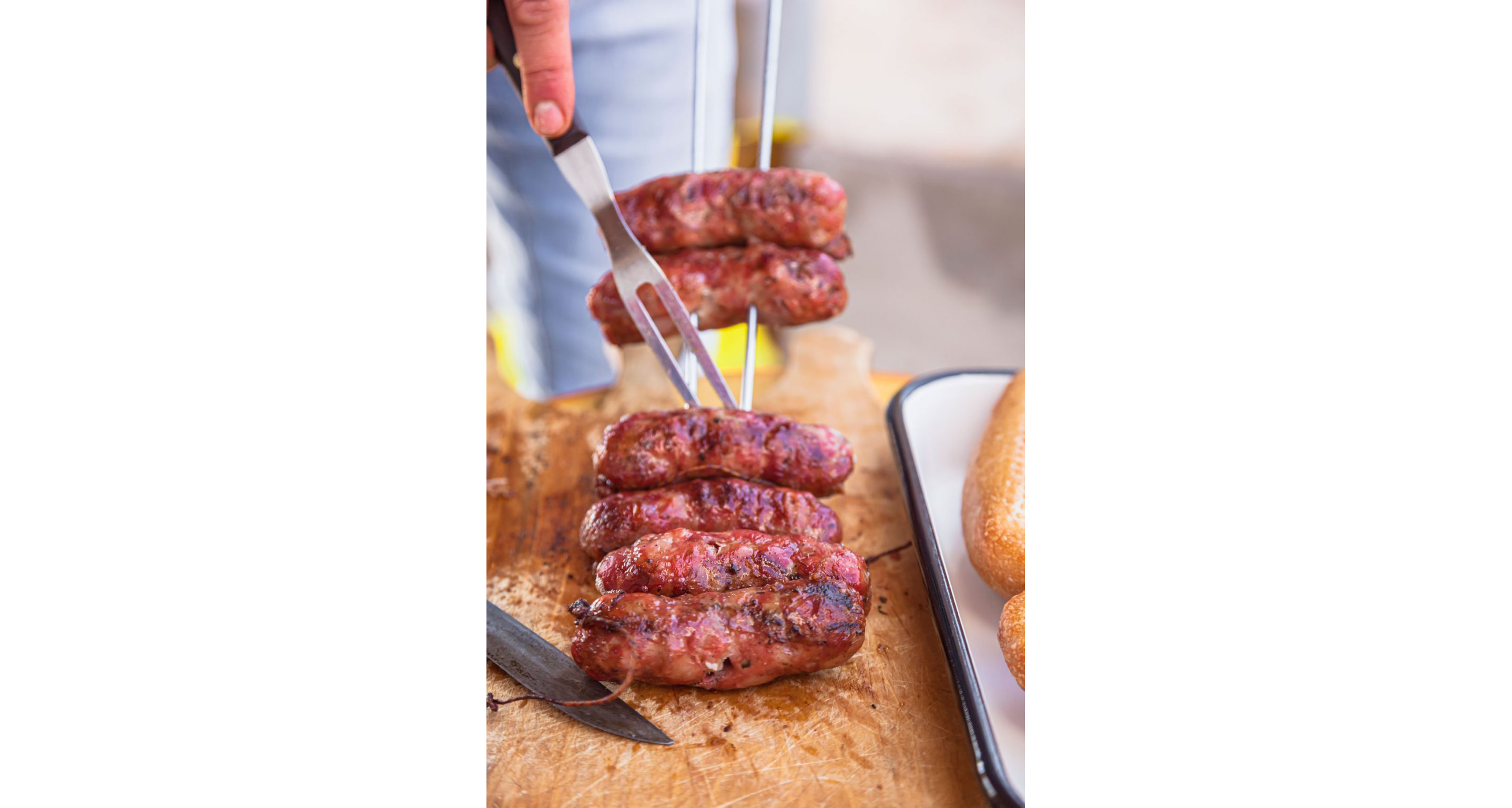 A metal skewer holding grilled sausages.