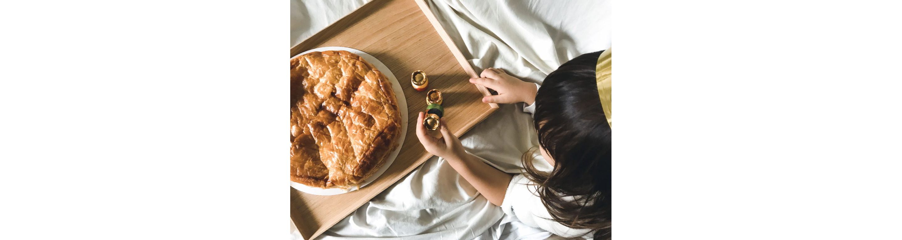 A galette des rois, or king cake, resting on a wooden tray.