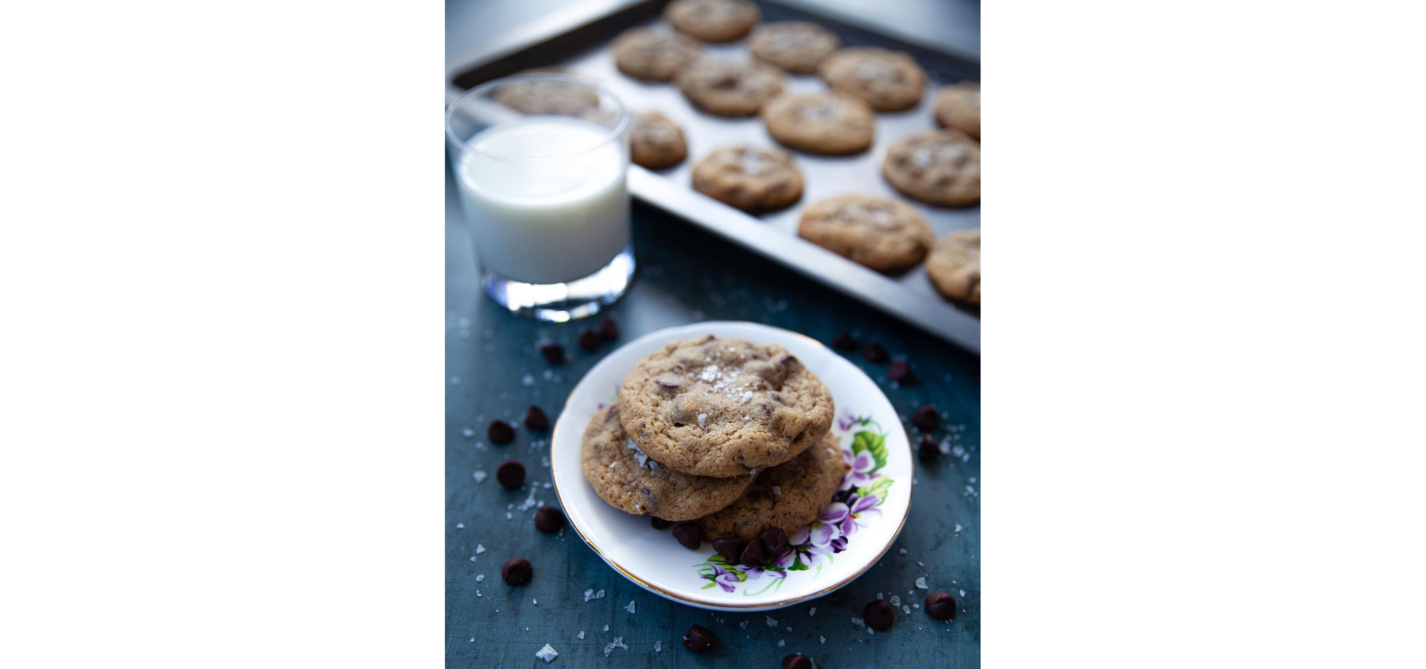 A plate of licorice cookies and a glass of milk.