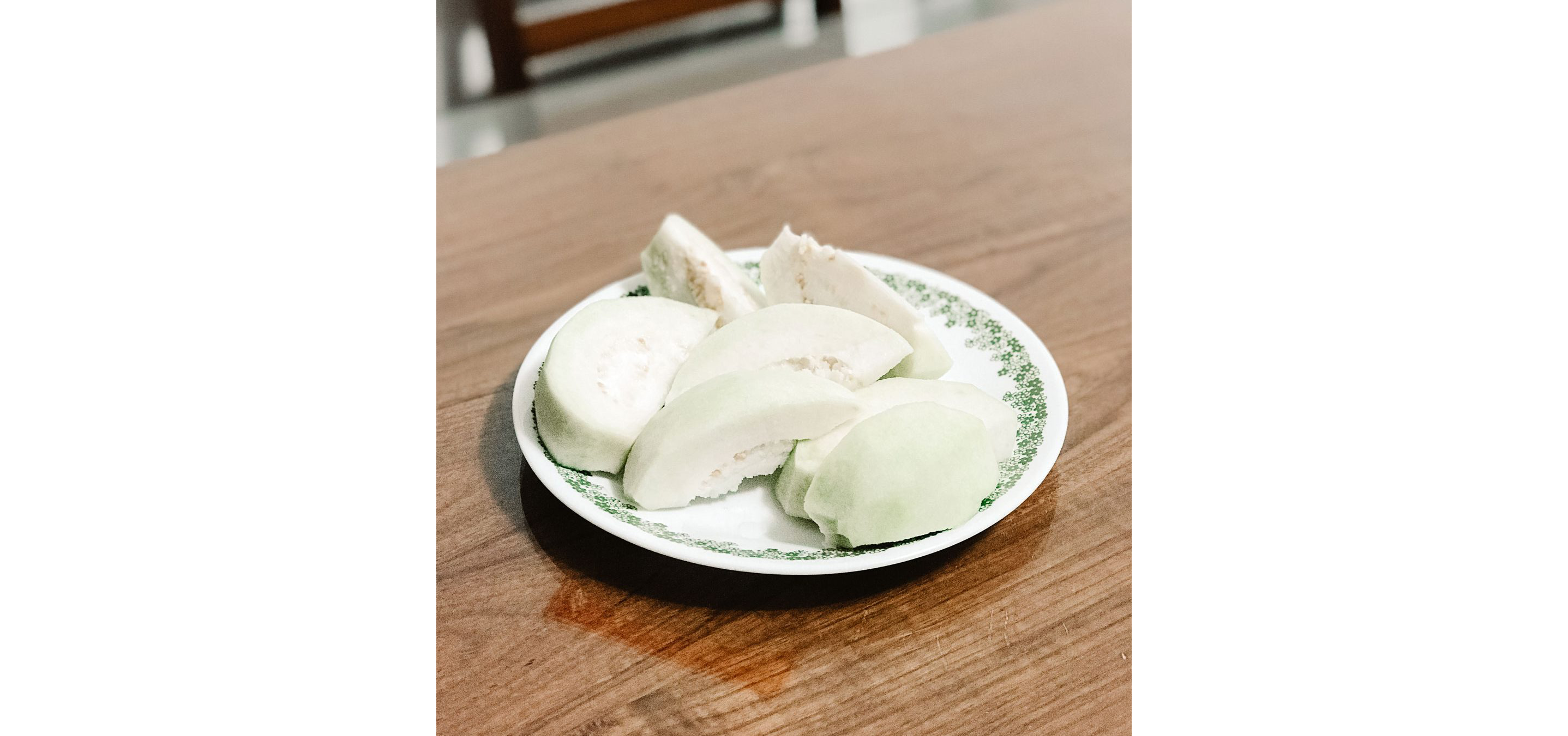 A small, delicate plate holding sliced fruit.