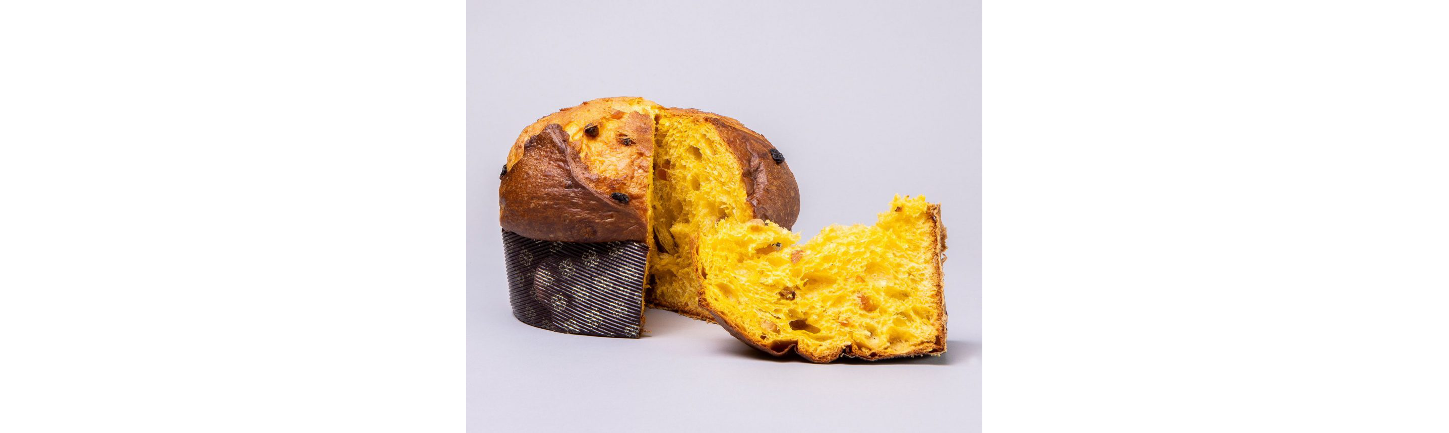 A loaf of panettone with a clean slice resting next to it.