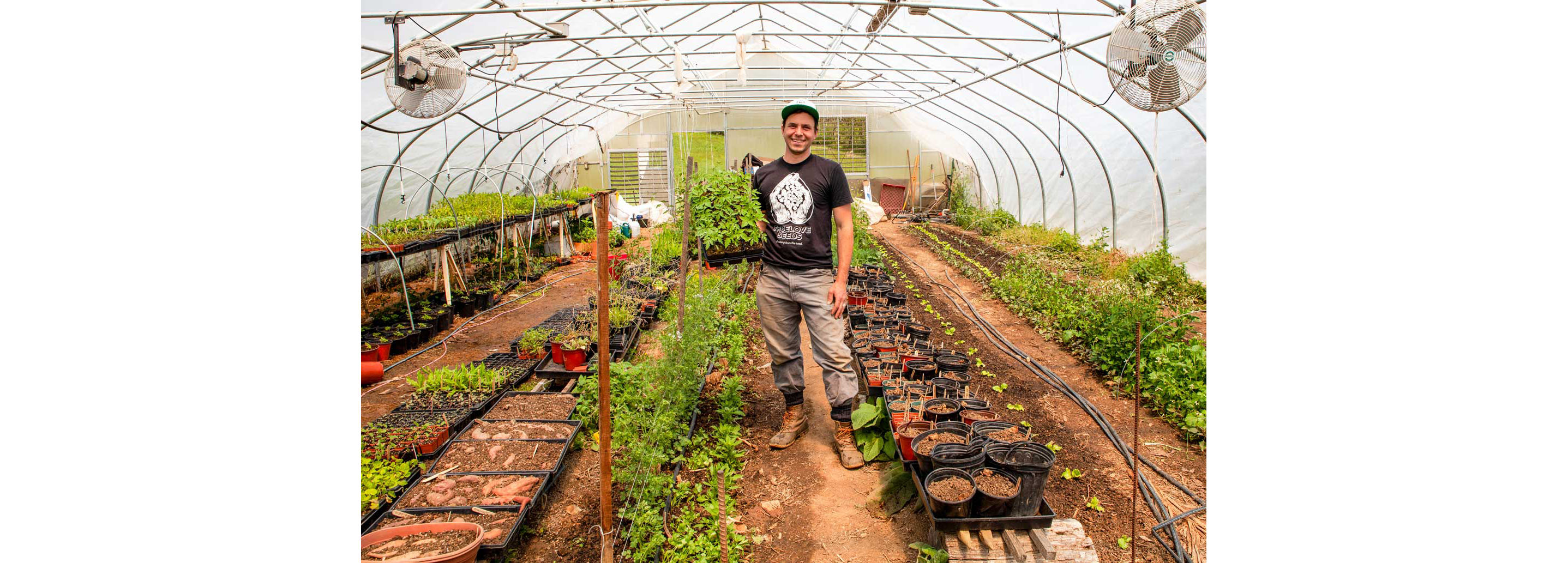 A gardener proudly showing off his nursery plants.