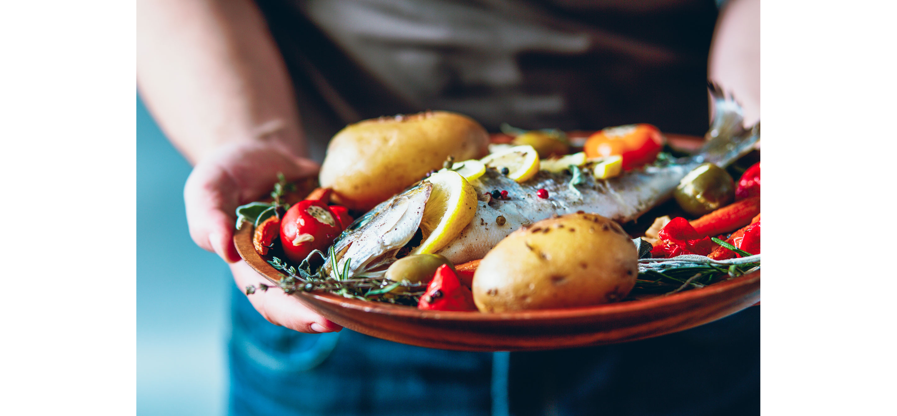 A plate of freshly cooked freshwater fish and whole potatoes.