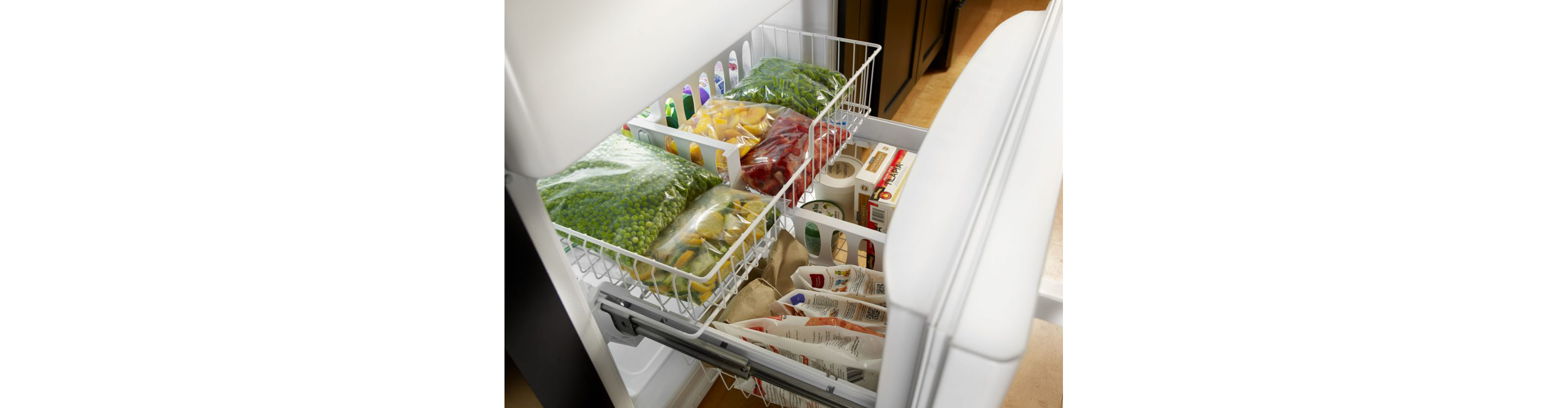 A freezer filled with separate plastic bags of frozen fruits and vegetables.