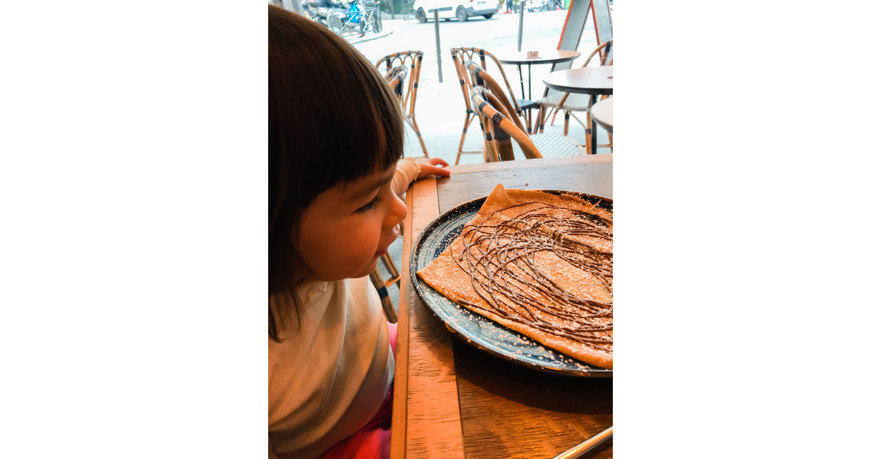 A crepe drizzled in chocolate served for a young child.