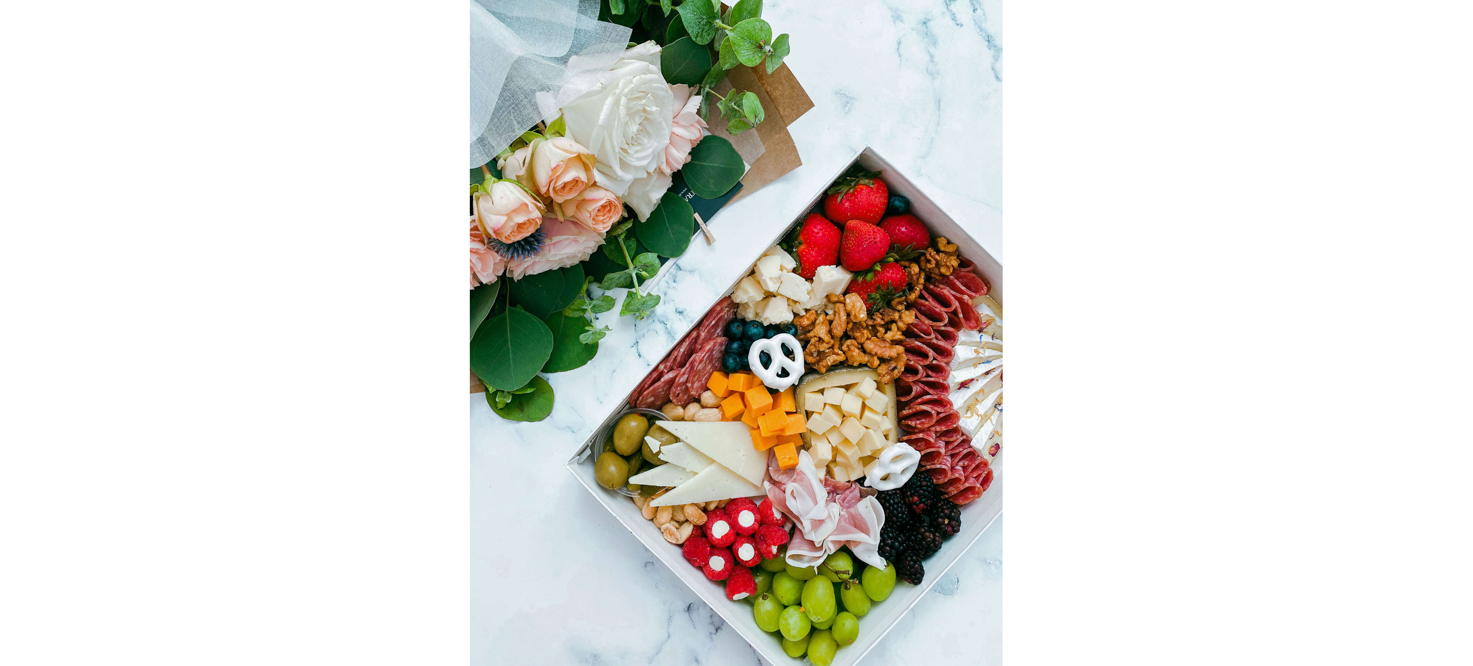 A picnic box filled with a variety of meats and cheeses.