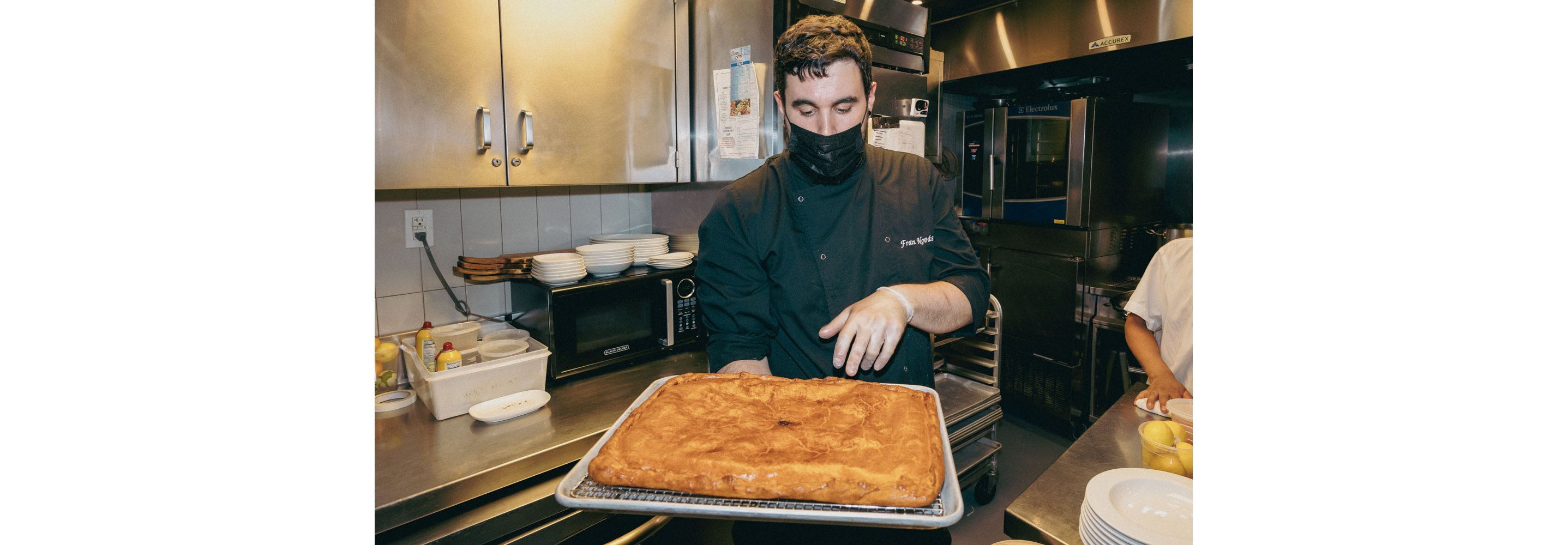 A chef holding a newly baked dish.