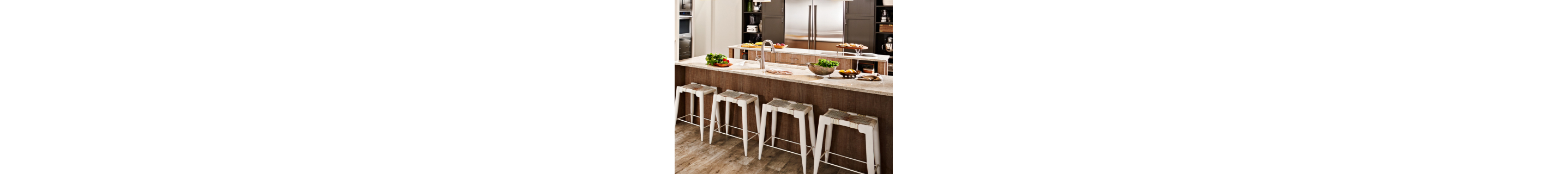 A kitchen island with four stools and appetizers on the counter.