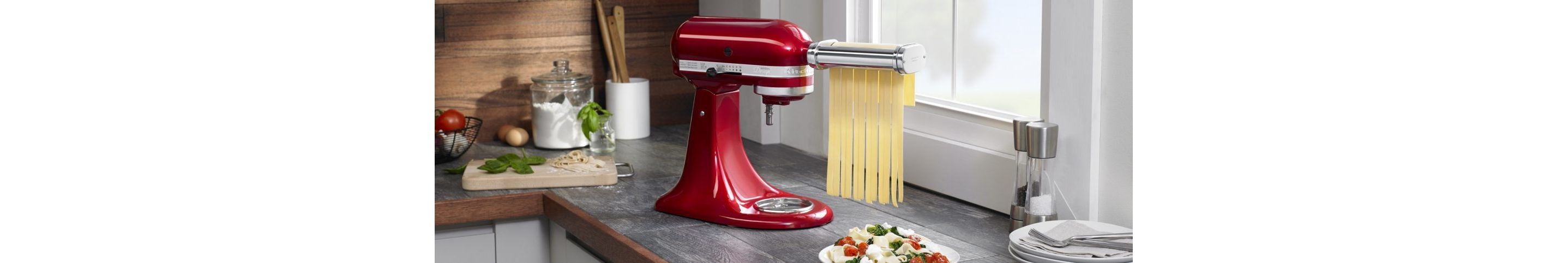 KitchenAid® stand mixer with pasta attachment cutting dough into ribbons