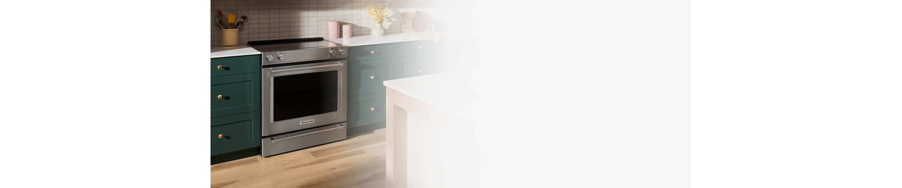 Electric range next to green cabinets
