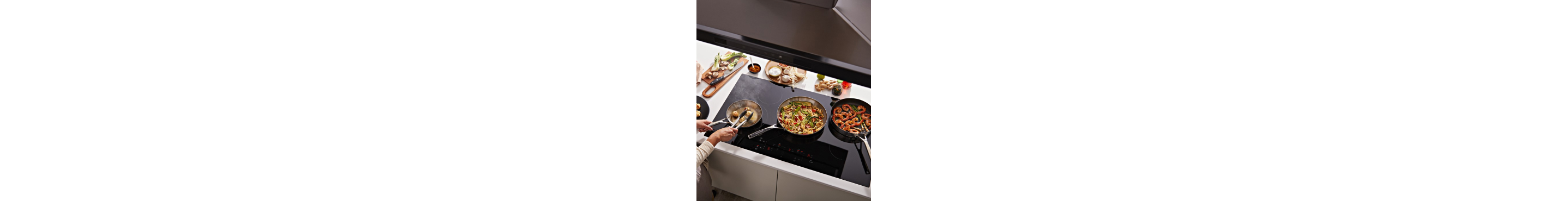 A person cooking on a KitchenAid® cooktop