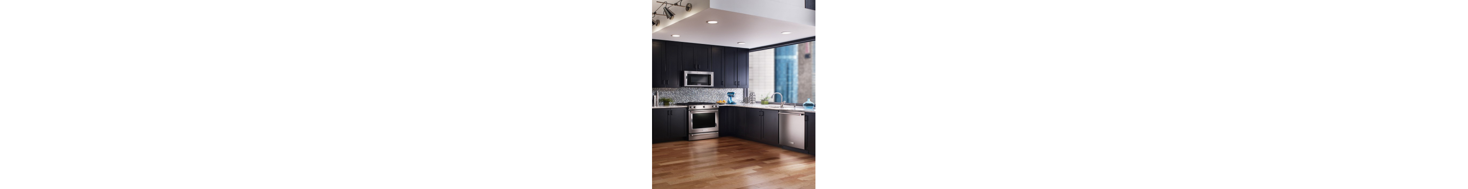 An open kitchen layout with dark cabinets and stainless steel appliances