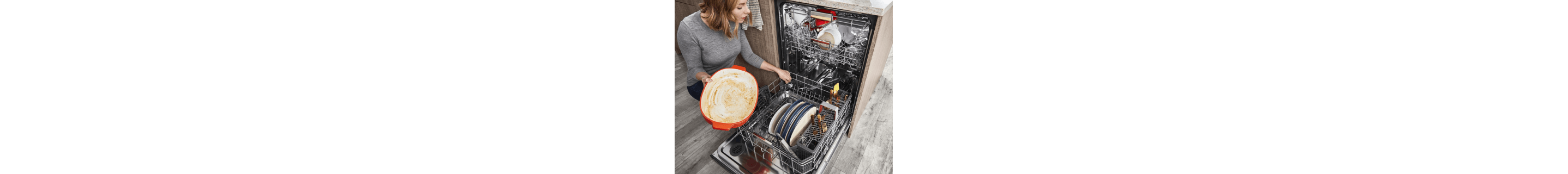 Person kneeling and filling dishwasher bottom rack