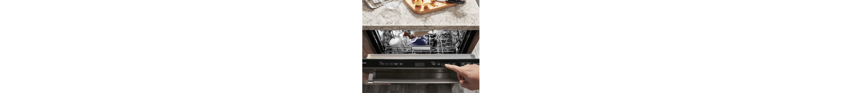 Top view of a slightly ajar front control panel dishwasher door with a loaded top rack