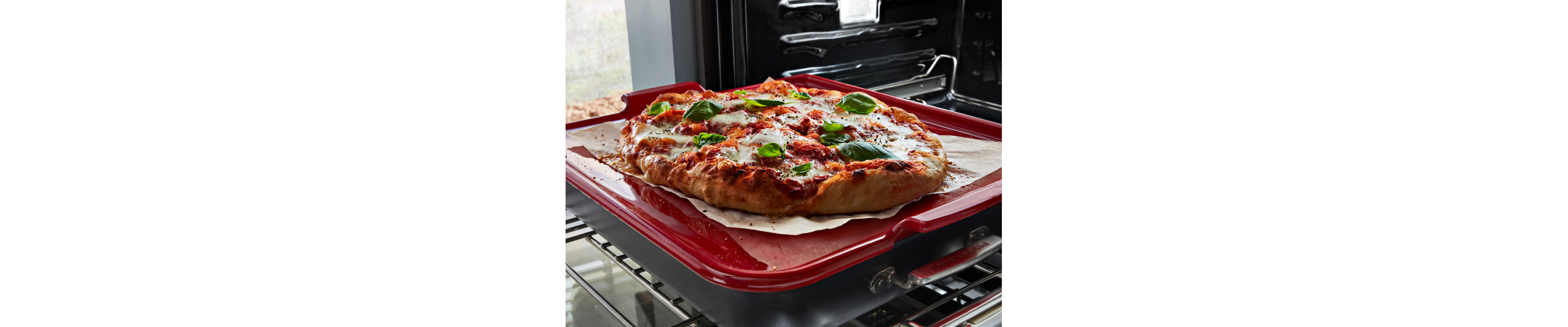  A pizza topped with fresh vegetables on a red baking stone