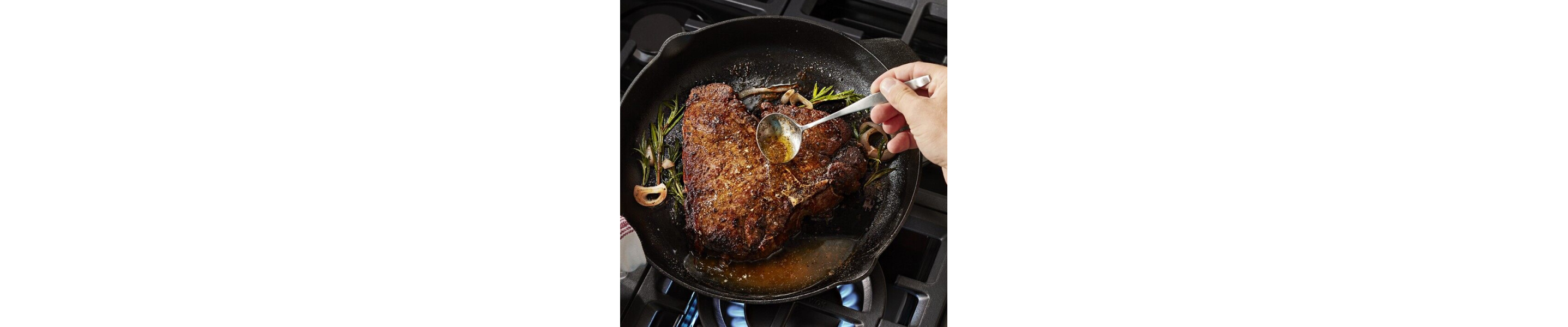 Steak being basted in a cast iron skillet