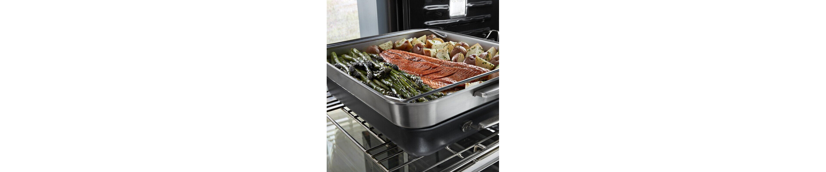 Salmon, potatoes and asparagus on a pan entering the oven