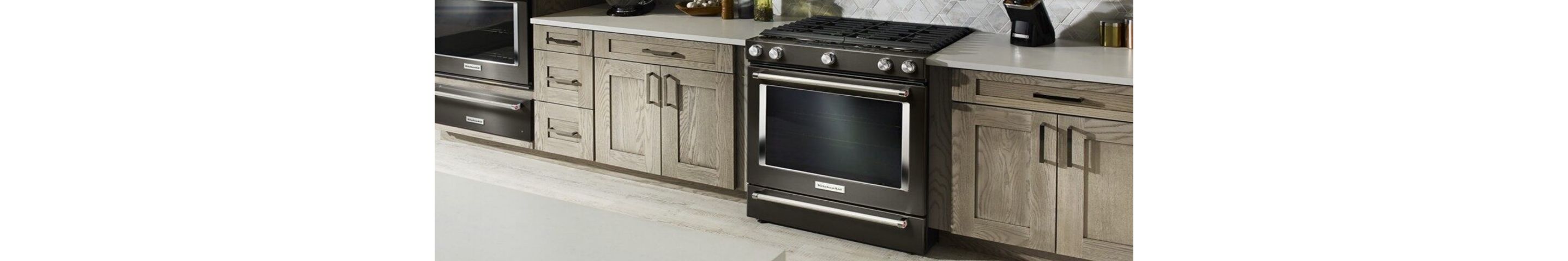 A black, self-cleaning oven installed in a clean, fully stocked kitchen.