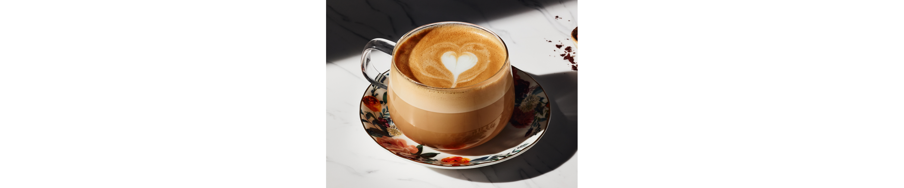 Cappuccino in glass teacup on small plate