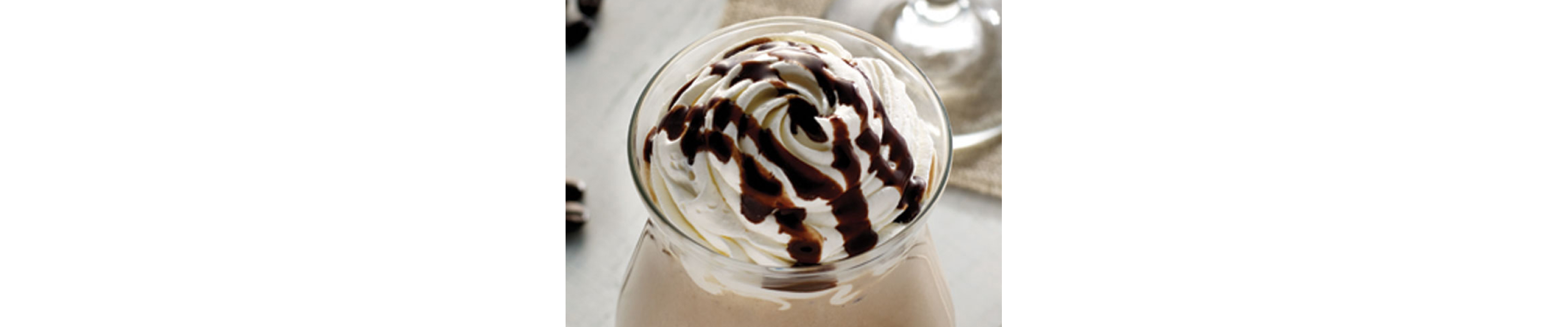 Whipped topping with chocolate drizzle in coffee cup