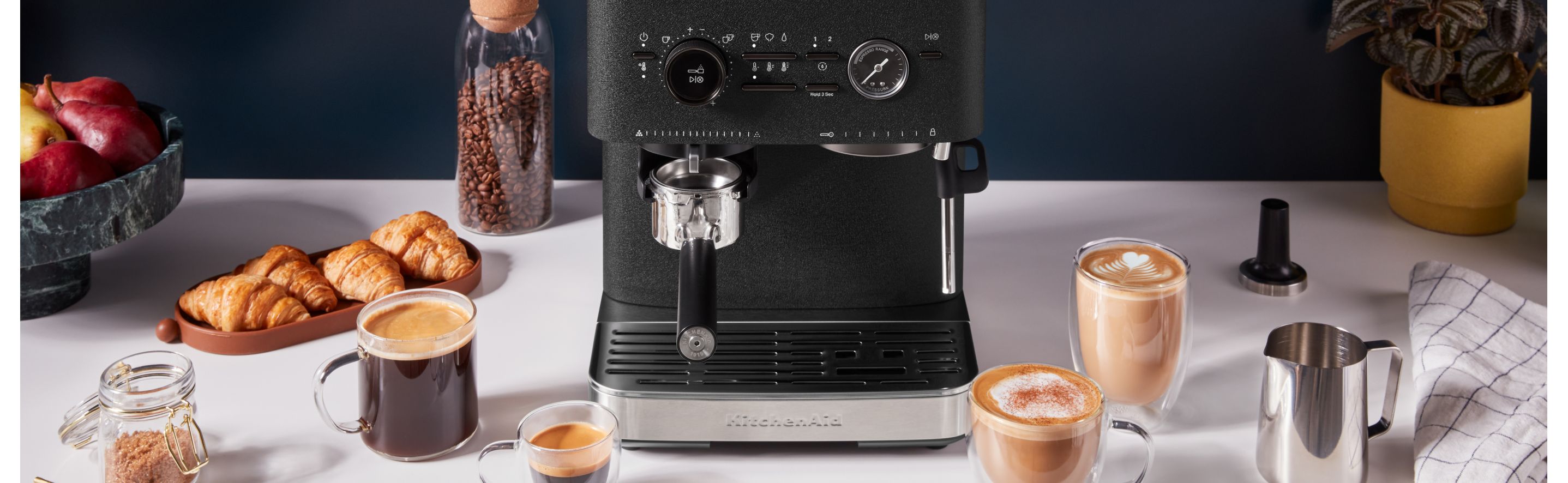 KitchenAid® Semi Automatic Espresso Machine next to a variety of espresso beverages