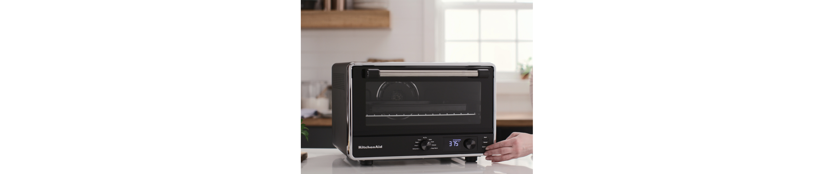 A person using a KitchenAid® countertop oven.