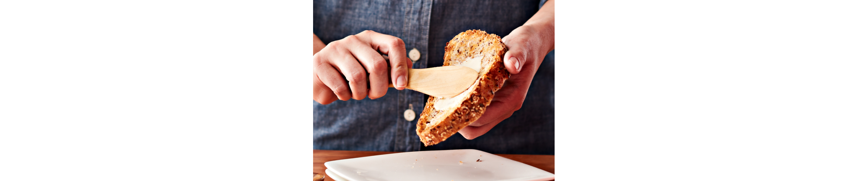 Person spreading butter on bread