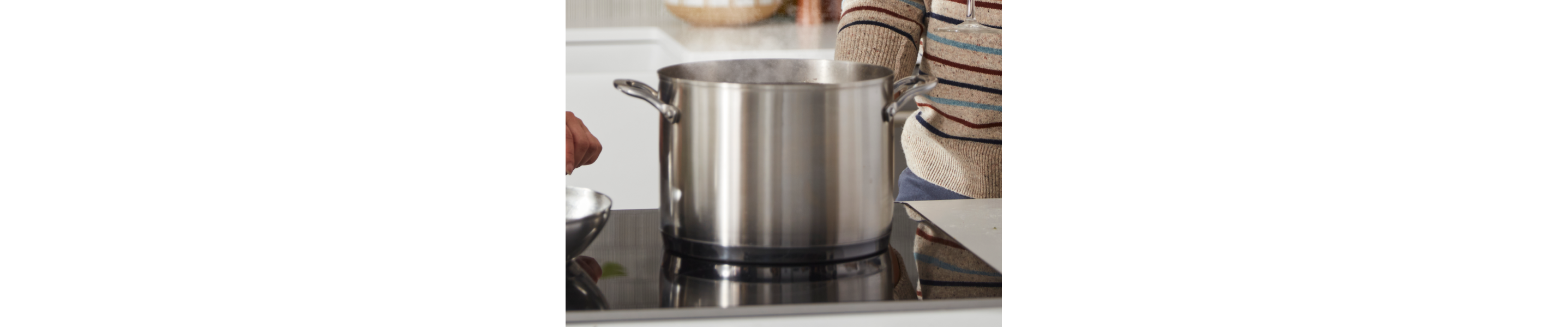 A large pot of steaming, boiling water on a KitchenAid® electric stovetop.