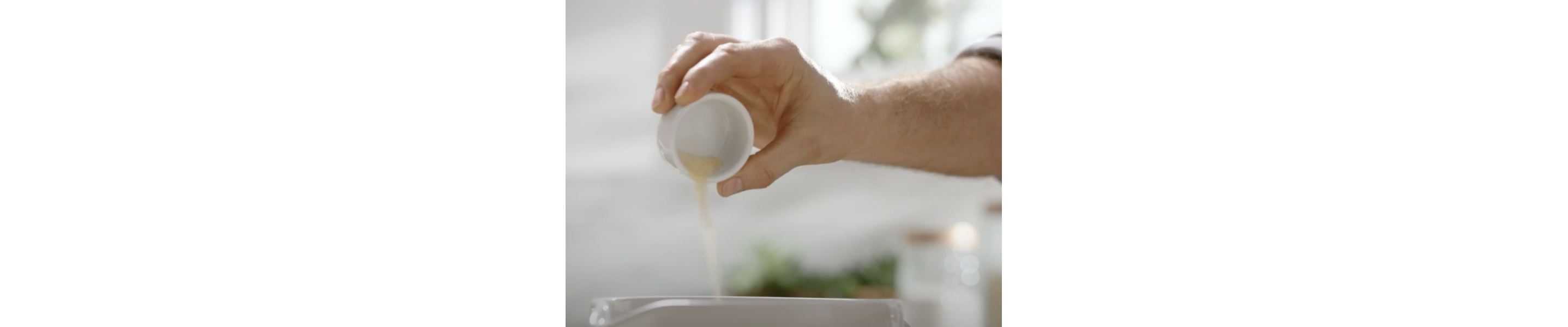 Person pouring seasonings from a small bowl