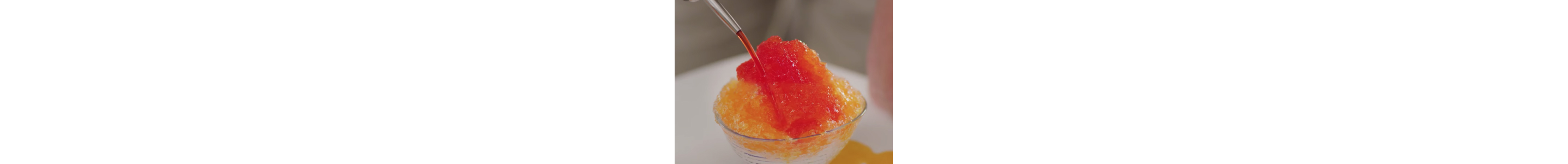 Syrup being poured on shave ice