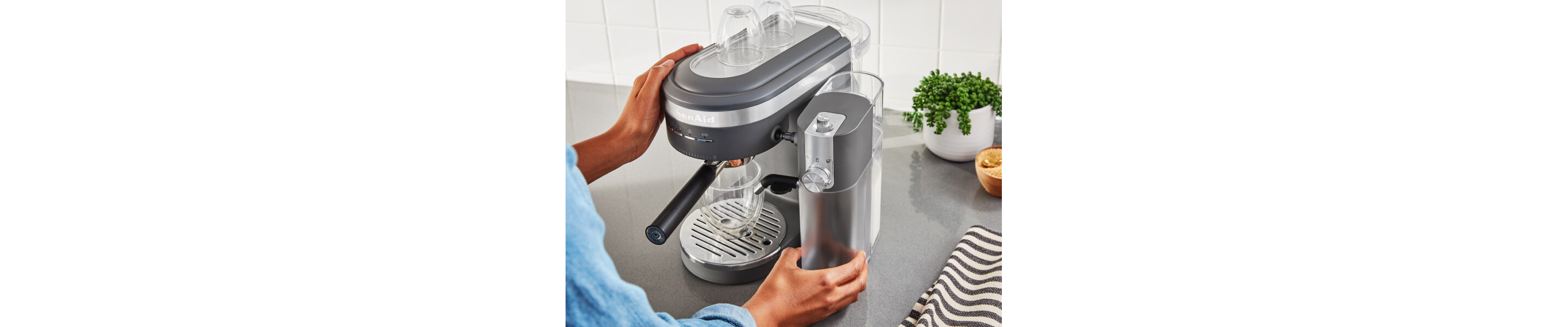 Person placing an espresso machine water tank onto an espresso machine