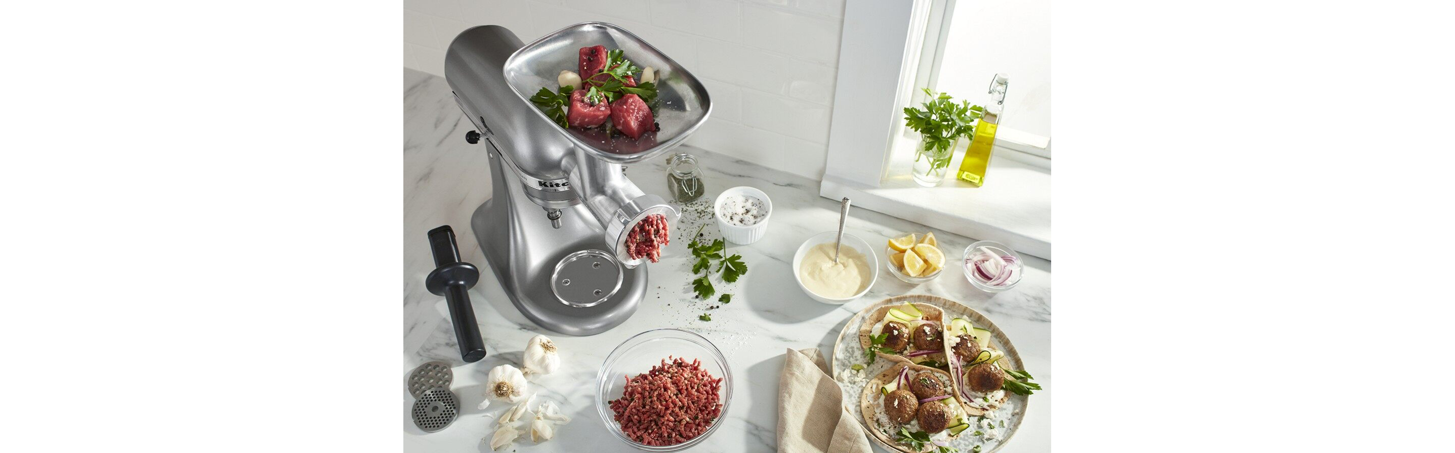 Kitchenaid® food and meat grinder attachment on silver stand mixer grinding meat