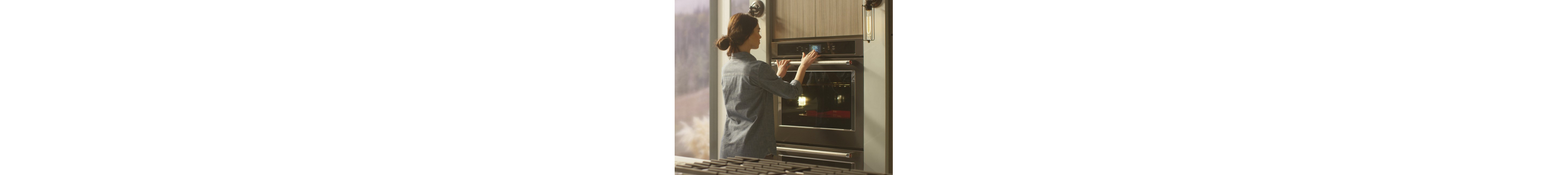 Person selecting settings on a double wall oven