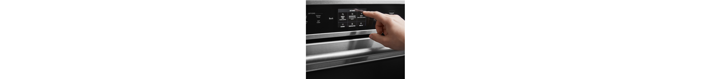 Hand adjusting settings on an oven’s control panel
