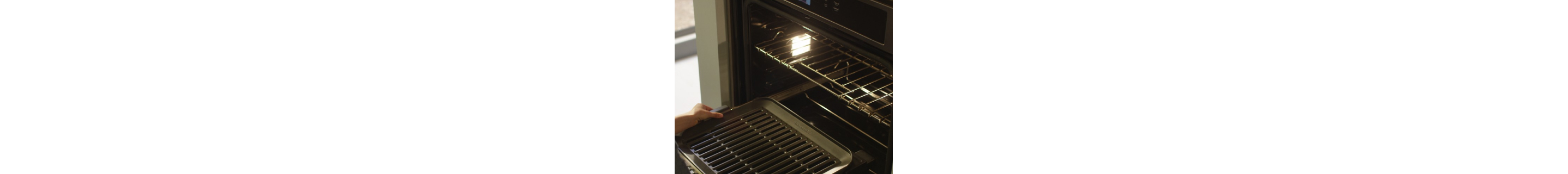 An opened oven revealing the interior light
