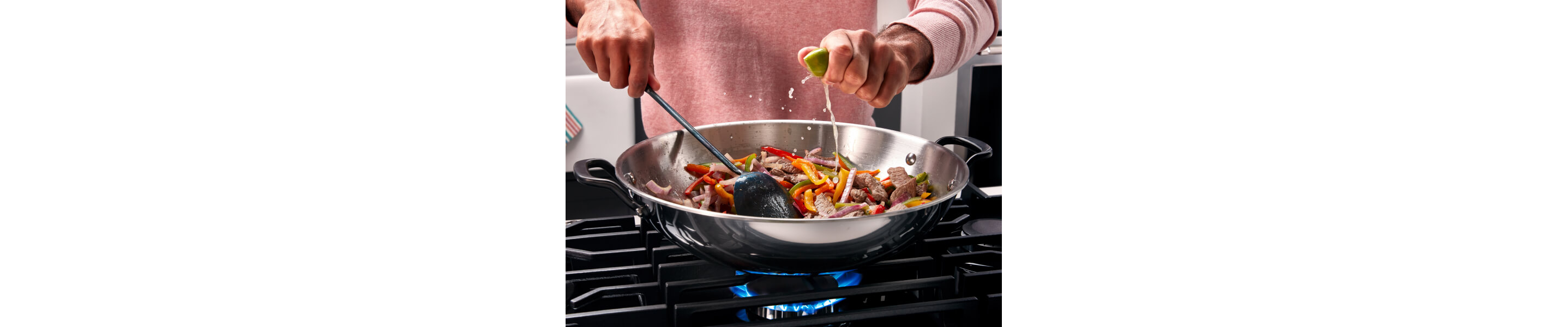 Someone cooking vegetables in a pan on their cooktop
