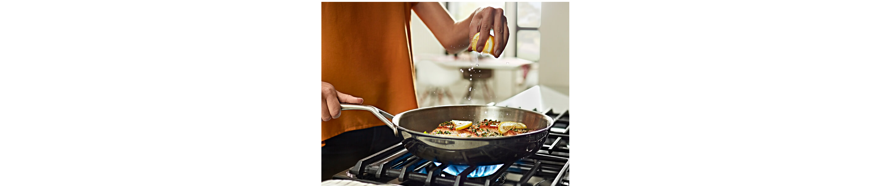 A person cooking food in a pan on a cooktop