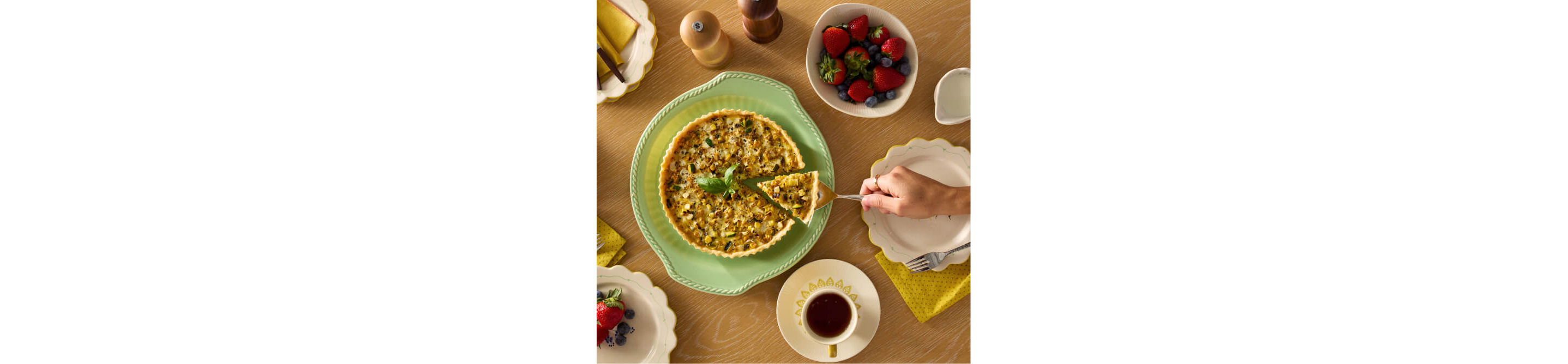 A person serving a wedge of quiche.